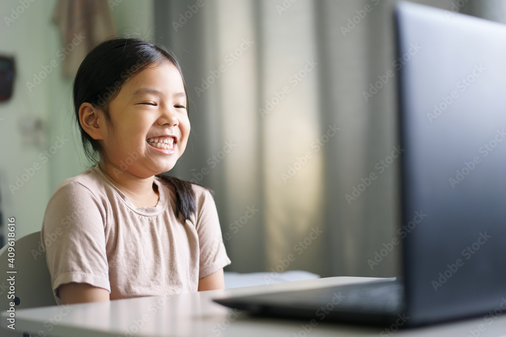 Asian child student or kid girl smile enjoy and laugh on computer notebook for e-learning communication or study online and people learn from home to playing laptop for education by back to school Asian child student or kid girl smile enjoy and laugh on computer notebook for e-learning communication or study online and people learn from home to playing laptop for education by back to school