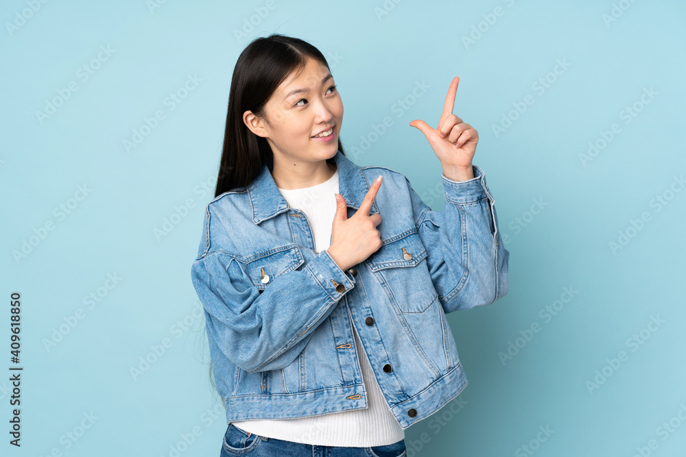 Young asian woman isolated on background pointing with the index finger a great idea Young asian woman isolated on background pointing with the index finger a great idea