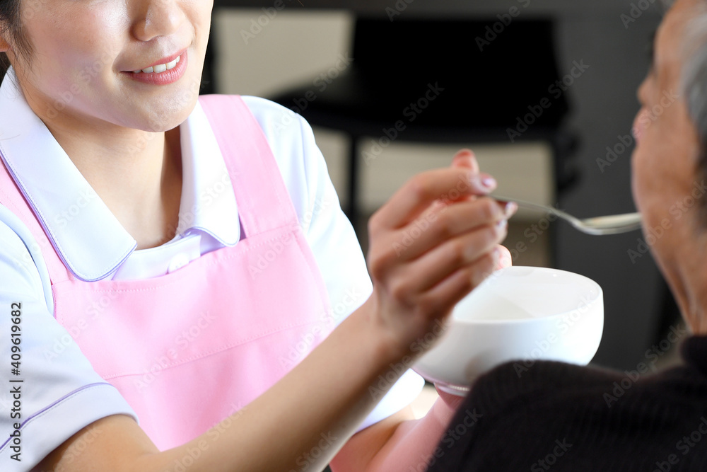シニア男性に食事の介助をするエプロン姿の若い女性 Stock Foto Adobe Stock シニア男性に食事の介助をするエプロン姿の若い女性 Stock Foto Adobe Stock