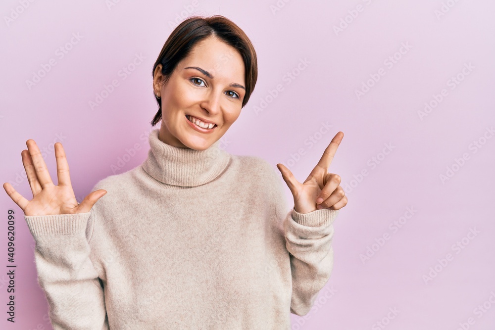 Young brunette woman with short hair wearing casual winter sweater showing and pointing up with fingers number seven while smiling confident and happy. Young brunette woman with short hair wearing casual winter sweater showing and pointing up with fingers number seven while smiling confident and happy.