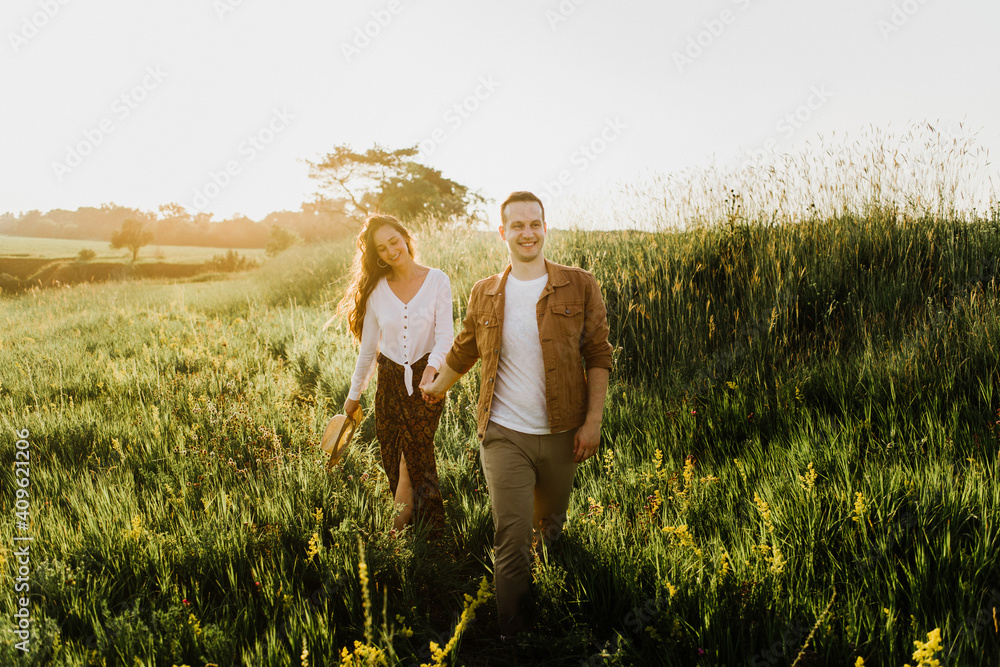 Beautiful young woman and a man walk, hug and kiss in nature at sunset. Beautiful young woman and a man walk, hug and kiss in nature at sunset.