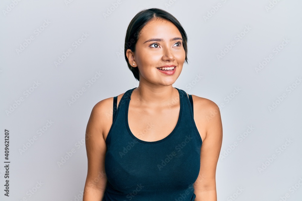 Beautiful young woman with short hair wearing casual clothes looking to side, relax profile pose with natural face and confident smile.