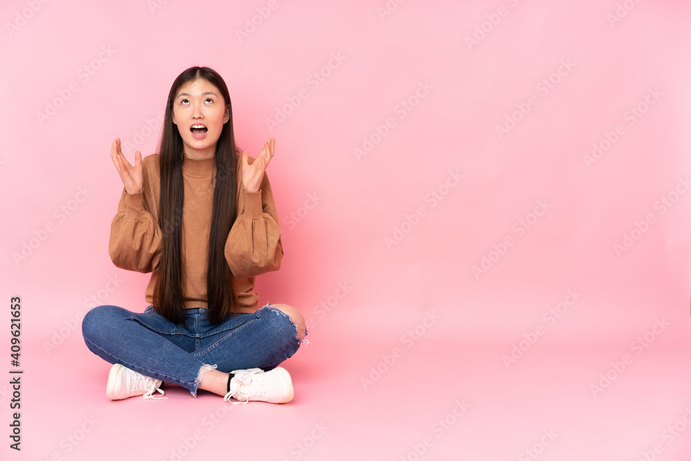 Young asian woman sitting on the floor isolated on pink background frustrated by a bad situation Young asian woman sitting on the floor isolated on pink background frustrated by a bad situation