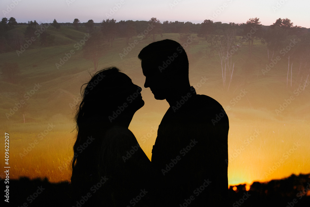 Silhouette of a woman and a man at sunset.