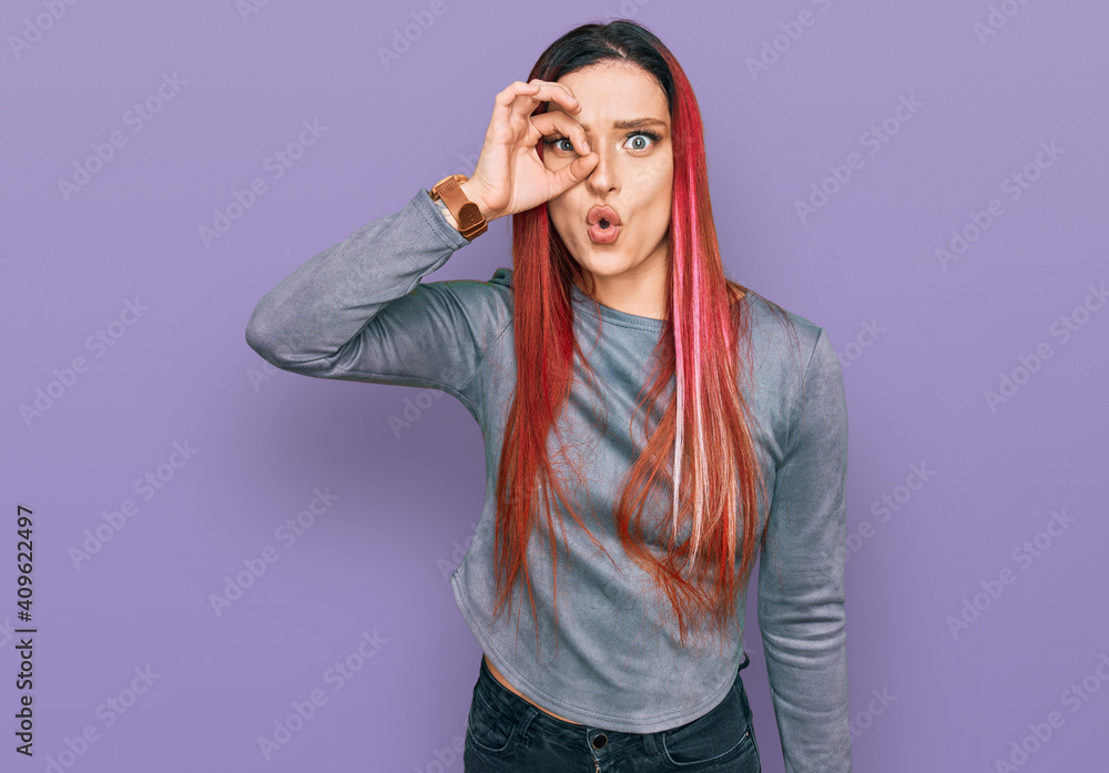 Young caucasian woman wearing casual clothes doing ok gesture shocked with surprised face, eye looking through fingers. unbelieving expression. Young caucasian woman wearing casual clothes doing ok gesture shocked with surprised face, eye looking through fingers. unbelieving expression.