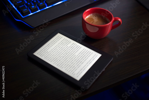 The person is reading the digital book while drinking coffee.