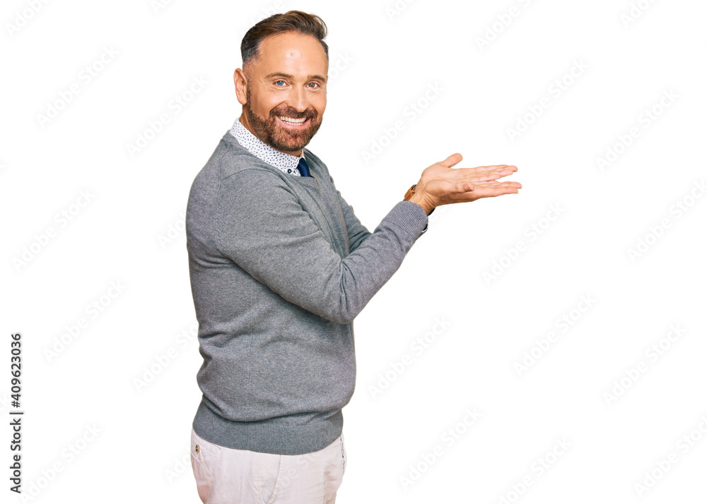 Handsome middle age man wearing business clothes pointing aside with hands open palms showing copy space, presenting advertisement smiling excited happy Handsome middle age man wearing business clothes pointing aside with hands open palms showing copy space, presenting advertisement smiling excited happy