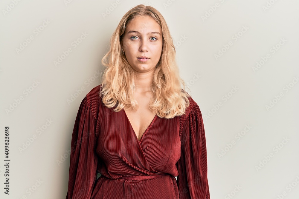 Young blonde girl wearing casual clothes with serious expression on face. simple and natural looking at the camera. Young blonde girl wearing casual clothes with serious expression on face. simple and natural looking at the camera.