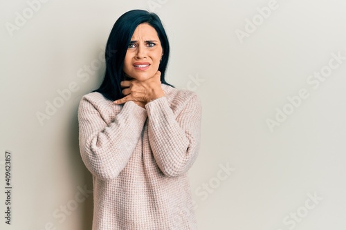 Young caucasian woman wearing casual winter sweater shouting and suffocate because painful strangle. health problem. asphyxiate and suicide concept. © Krakenimages.com