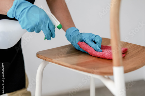 A man cleaning his chair, he injects a solution and uses a pink tablecloth to clean it, cleaning to prevent the transmission of COVID-19, COVID-19 prevention concept.