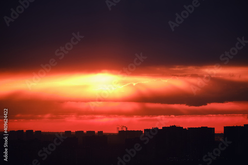 Top view of the city at dusk. Setting night sun behind the silhouettes of houses. Nightfall in the big city