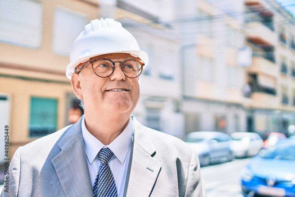 Senior grey-haired architect man smiling happy walking at street of city Senior grey-haired architect man smiling happy walking at street of city