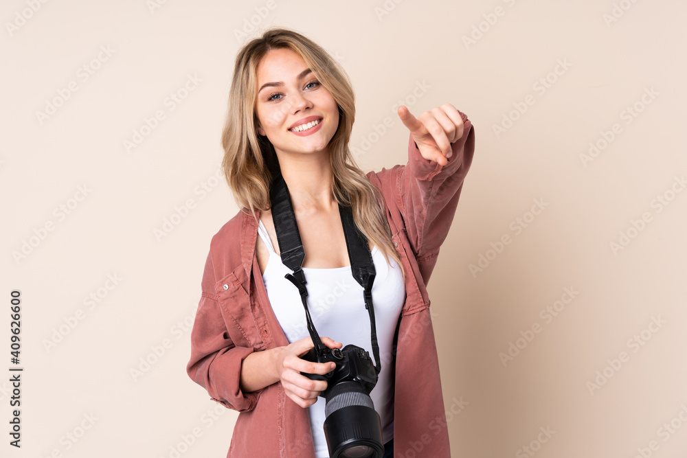 Young photographer girl over isolated background points finger at you while smiling Young photographer girl over isolated background points finger at you while smiling