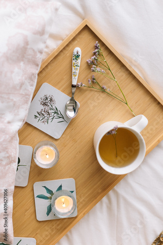 Cup of tea on a tray in the bedroom with candles