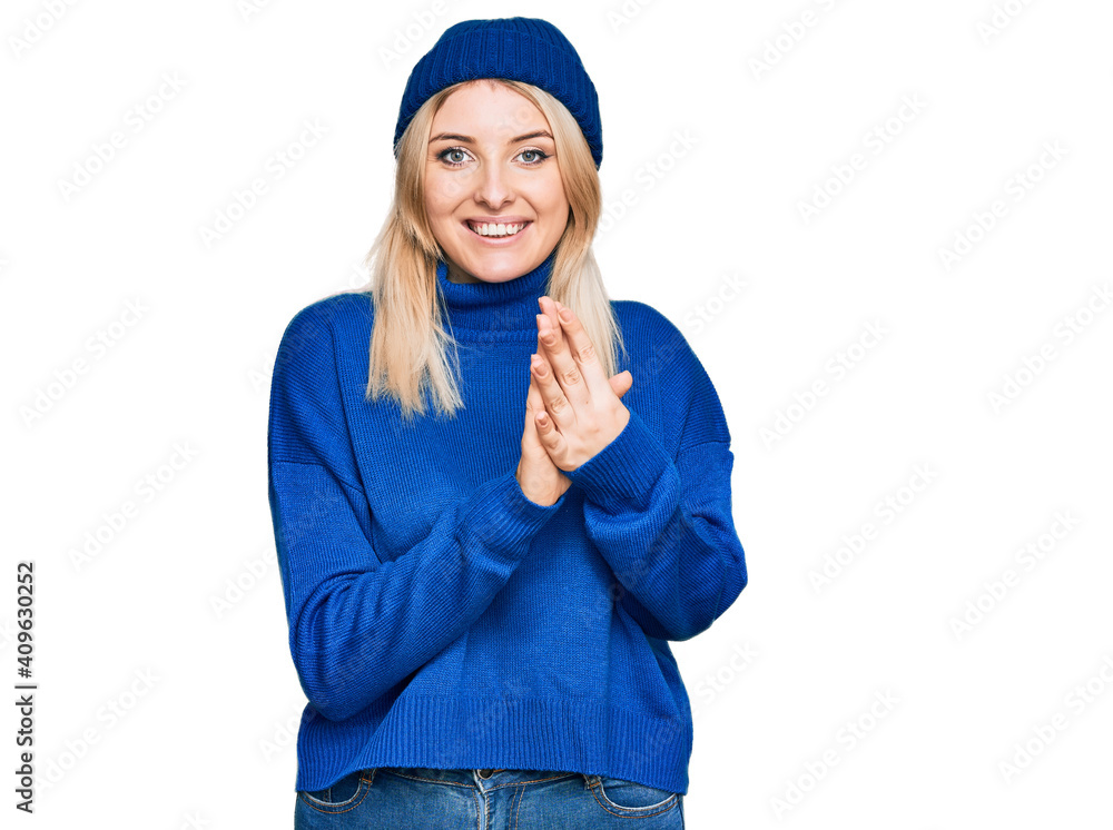 Young caucasian woman wearing wool winter sweater and cap praying with hands together asking for forgiveness smiling confident. Young caucasian woman wearing wool winter sweater and cap praying with hands together asking for forgiveness smiling confident.