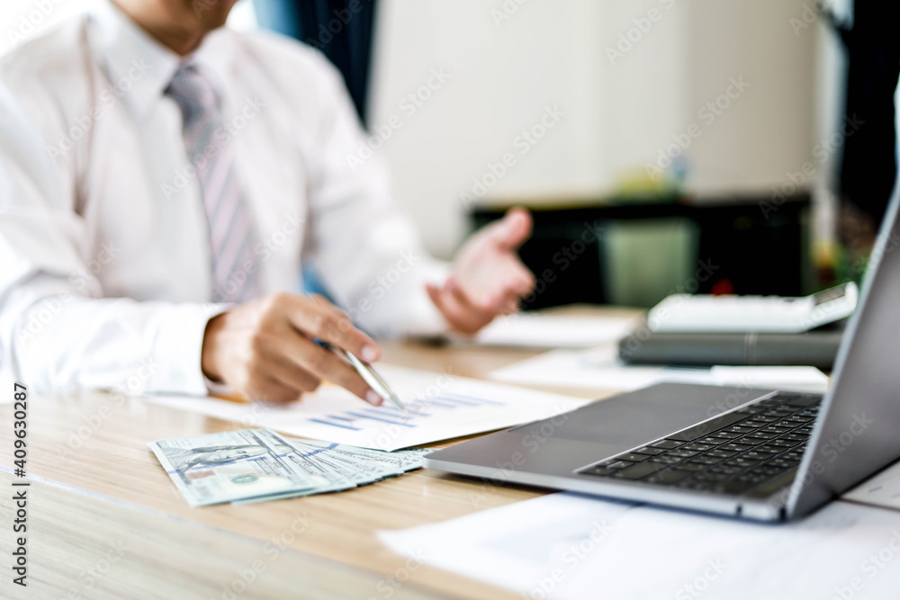The manager is reviewing the monthly sales papers in his office. He holds a sales summary document as a bar graph. Sales management concept. The manager is reviewing the monthly sales papers in his office. He holds a sales summary document as a bar graph. Sales management concept.