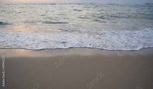 Ondulação marítima na areia da praia ao por-do-sol