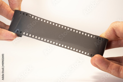 old photographic film in hands on white isolated background with copy space
