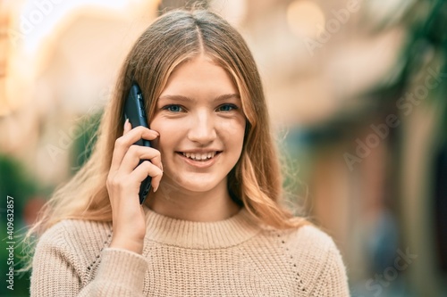 Beautiful caucasian teenager smiling happy talking on the smartphone at the city.