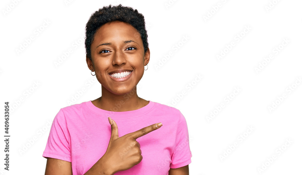 Young african american woman wearing casual clothes cheerful with a smile on face pointing with hand and finger up to the side with happy and natural expression Young african american woman wearing casual clothes cheerful with a smile on face pointing with hand and finger up to the side with happy and natural expression
