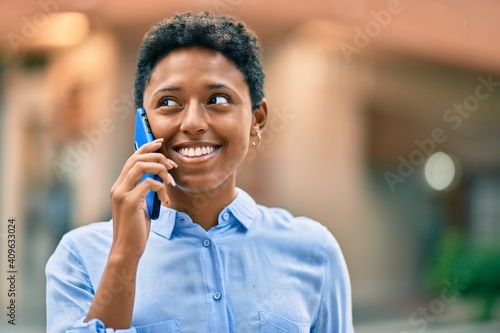 Young african american girl smiling happy talking on the smartphone at the city.