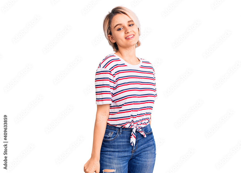Obraz premium Young beautiful blonde woman wearing casual clothes looking positive and happy standing and smiling with a confident smile showing teeth