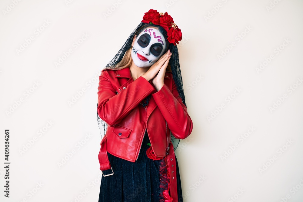 Woman wearing day of the dead costume over white sleeping tired dreaming and posing with hands together while smiling with closed eyes. Woman wearing day of the dead costume over white sleeping tired dreaming and posing with hands together while smiling with closed eyes.