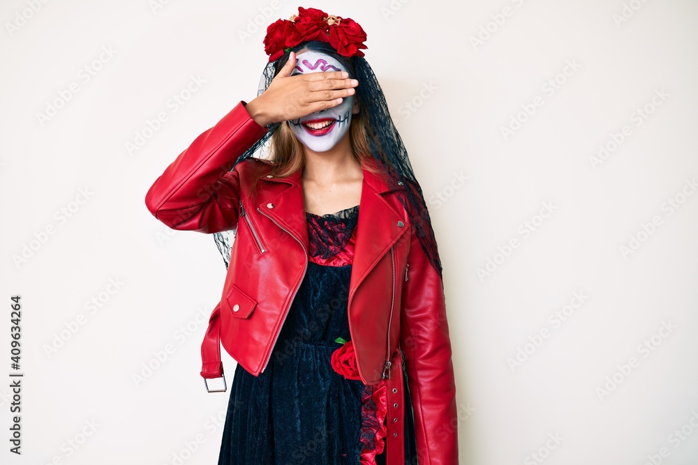 Woman wearing day of the dead costume over white smiling and laughing with hand on face covering eyes for surprise. blind concept.