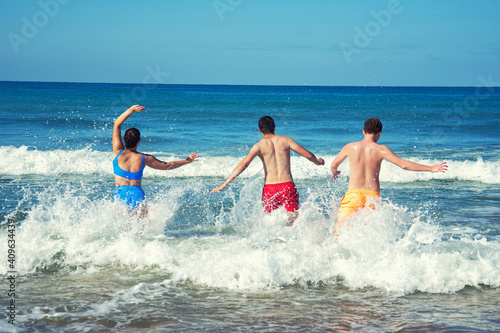 A cheerful company of friends is resting at the sea in summer.