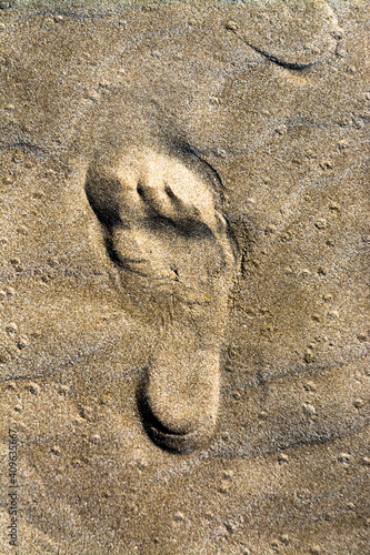 Human bared footprint on a sandy beach