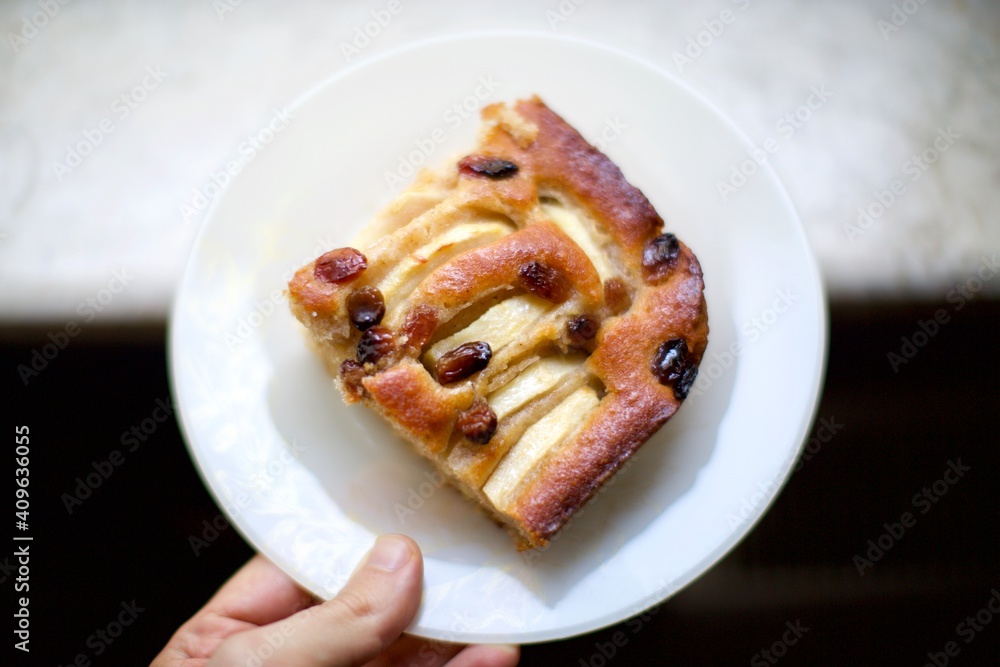 piece of cake with raisins and apples with natural light near the window. blurry view
piece of cake with raisins and apples with natural light near the window. blurry view