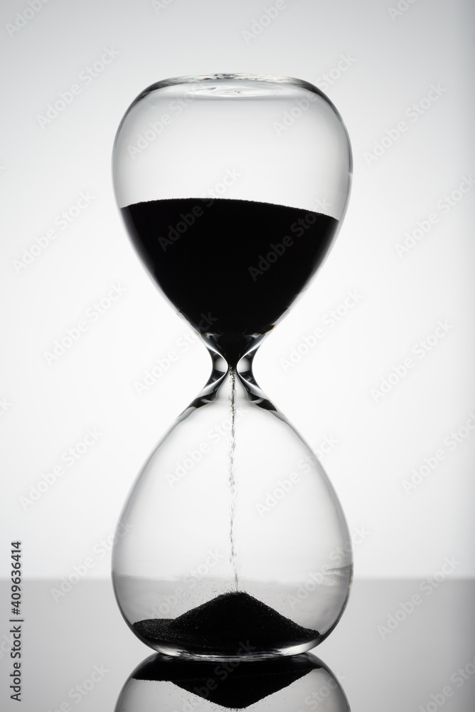 Sand moves through hourglass. Close up of hour glass clock. Old time classic sandglass timer. Hourglass as time passing concept for business deadline, urgency and running out of time Sand moves through hourglass. Close up of hour glass clock. Old time classic sandglass timer. Hourglass as time passing concept for business deadline, urgency and running out of time