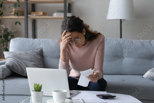 Unhappy young woman in glasses feeling stressed calculating monthly expenses at home, facing financial problems or lack of money for utility household or rental payments, bankruptcy concept. photo