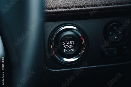 Modern car start and stop engine button - closeup of modern dashboard of modern day car, technology and safety power button. © Ismail Rajo
