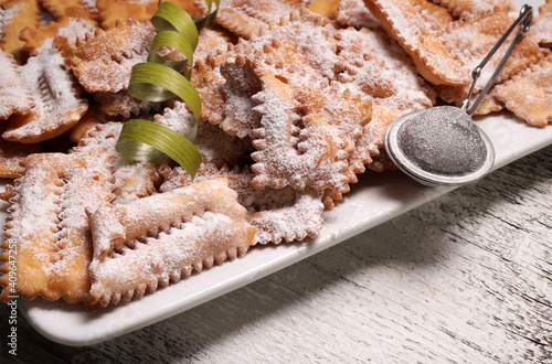 Vista dall'alto di dolci fatti in casa tradizionali di carnevale: chiacchiere su sfondo bianco. Copia spazio photo