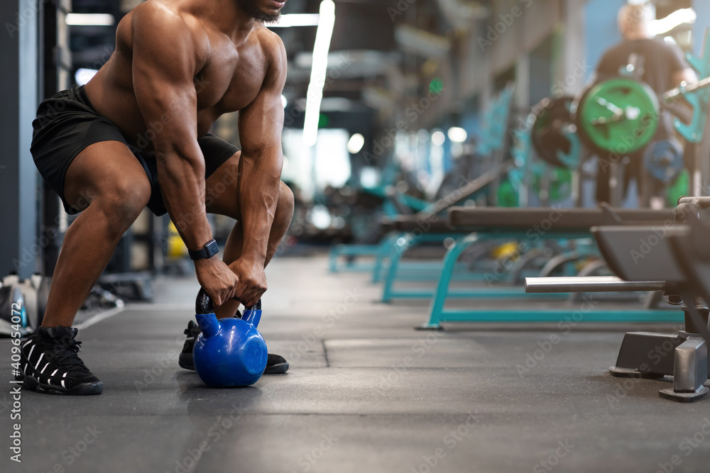 Cropped of black muscular man working out with kettlebell - obrazy, fototapety, plakaty 