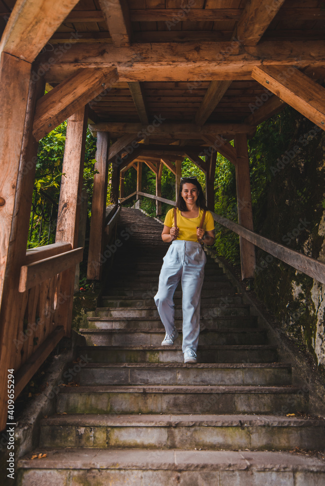 young smiling woman with brown leather walking down by stairs