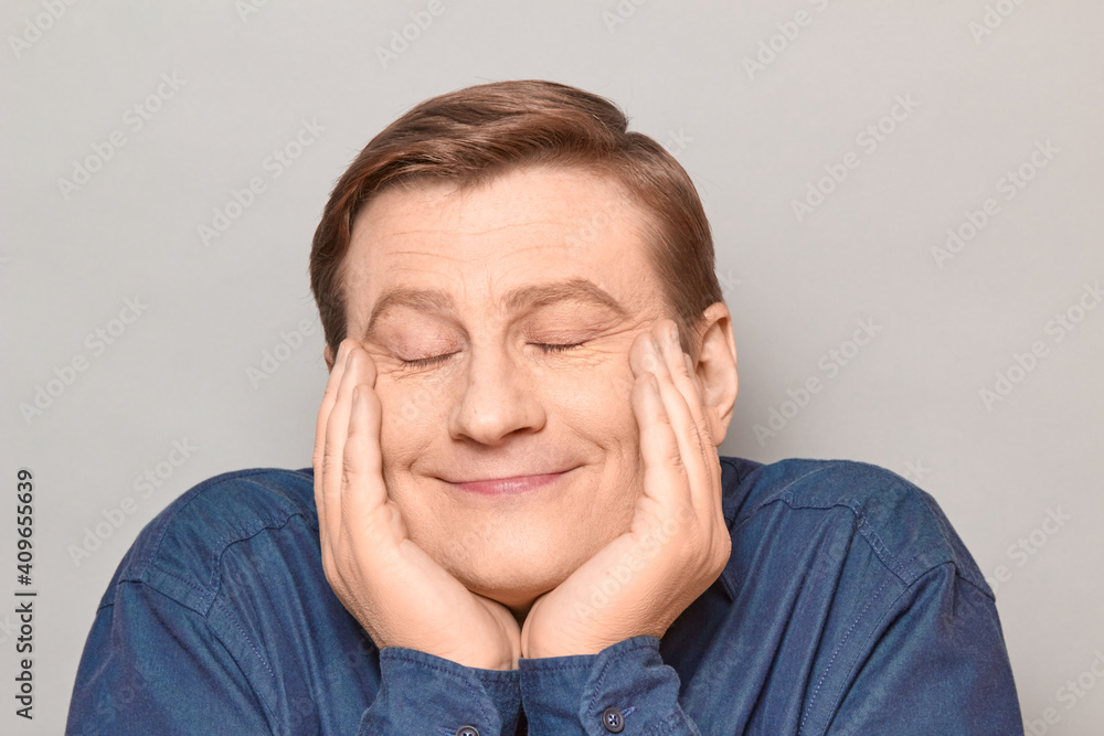 Portrait of funny cheerful man touching cheeks with hands and smiling Portrait of funny cheerful man touching cheeks with hands and smiling