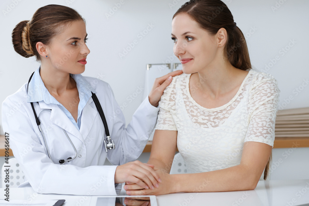 Woman-doctor reassuring her female patient while sitting at the desk. Medicine concept Woman-doctor reassuring her female patient while sitting at the desk. Medicine concept