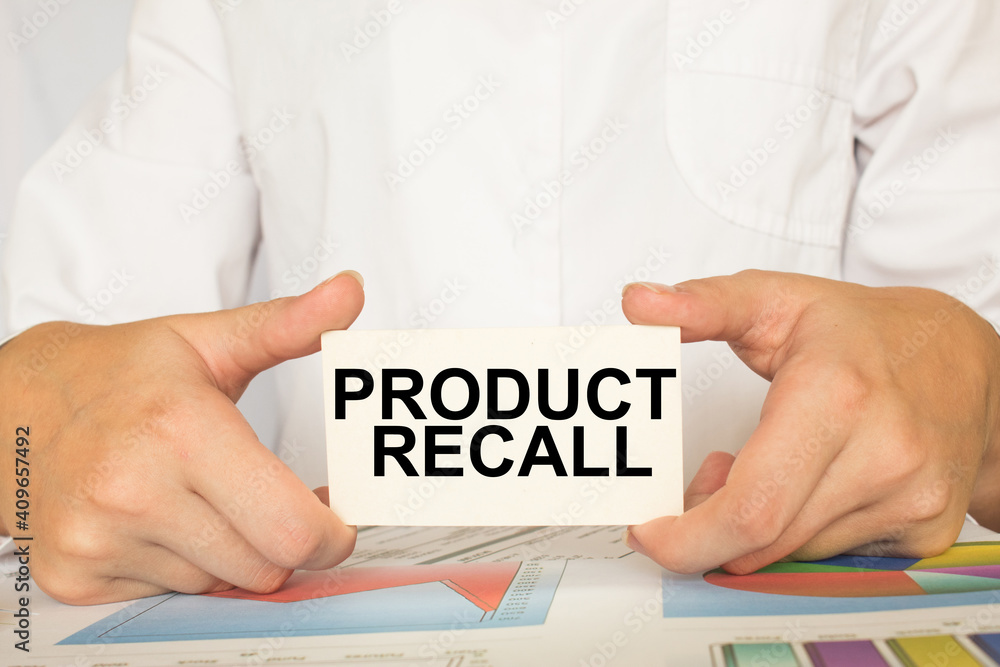 a man in the office holds a card with text PRODUCT RECALL . business concept a man in the office holds a card with text PRODUCT RECALL . business concept