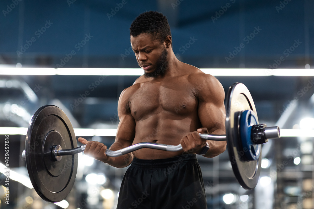 Closeup of muscular bodybuilder exercising with barbell at gym Closeup of muscular bodybuilder exercising with barbell at gym