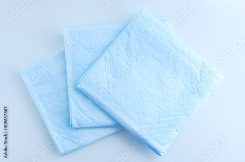 Medical blue absorbent diaper wipes on white background.