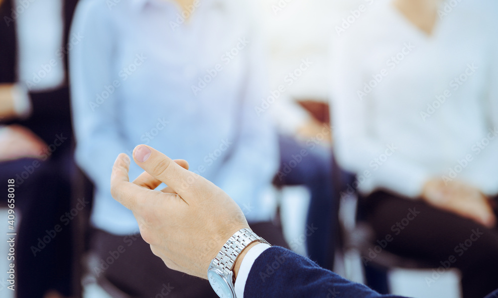 Business man making presentation to group of people in office. Speaker delivering a seminar to his colleagues. Teamwork and coaching concept Business man making presentation to group of people in office. Speaker delivering a seminar to his colleagues. Teamwork and coaching concept