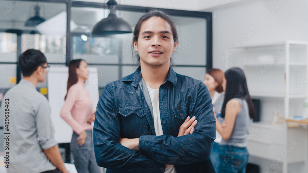 Portrait of successful handsome executive businessman smart casual wear looking at camera and smiling, arms crossed in modern office workplace. Young Asia guy standing in contemporary meeting room. Portrait of successful handsome executive businessman smart casual wear looking at camera and smiling, arms crossed in modern office workplace. Young Asia guy standing in contemporary meeting room.