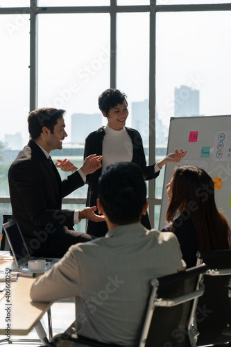 multiehthnic business team including caucasian and asian people  discussing about new project in office. diversity teamwork concept