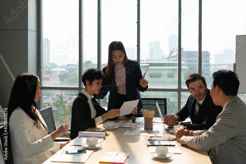 multiehthnic business team including caucasian and asian people  discussing about new project in office. diversity teamwork concept
