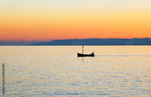 Fishing boat at sunset around the bay of Kardamyli village in Messiniaki Mani region of south Peloponnese in Greece. © Theastock