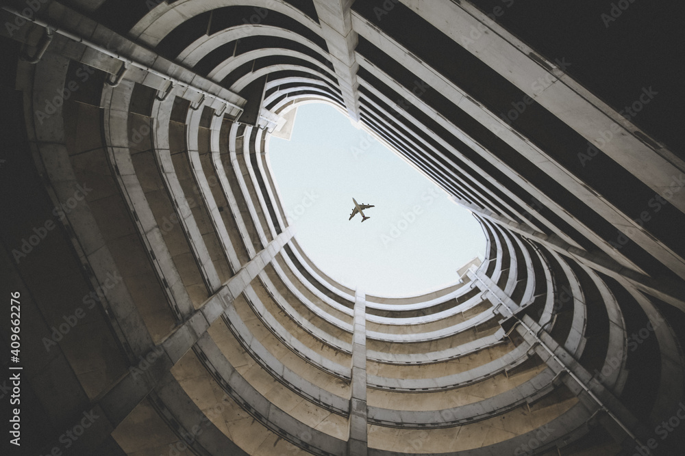 Bottom view photo of airplane passing in the middle of a building