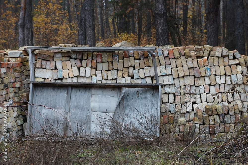 a pile of old gray and brown bricks in dry grass outside a pile of old gray and brown bricks in dry grass outside