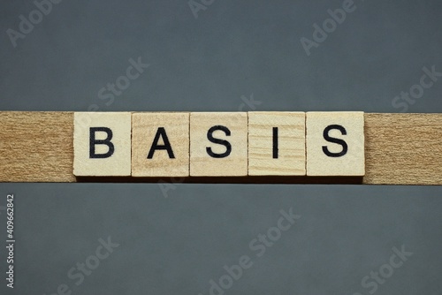 text the word basis from brown wooden small letters with black font on an gray table © butus